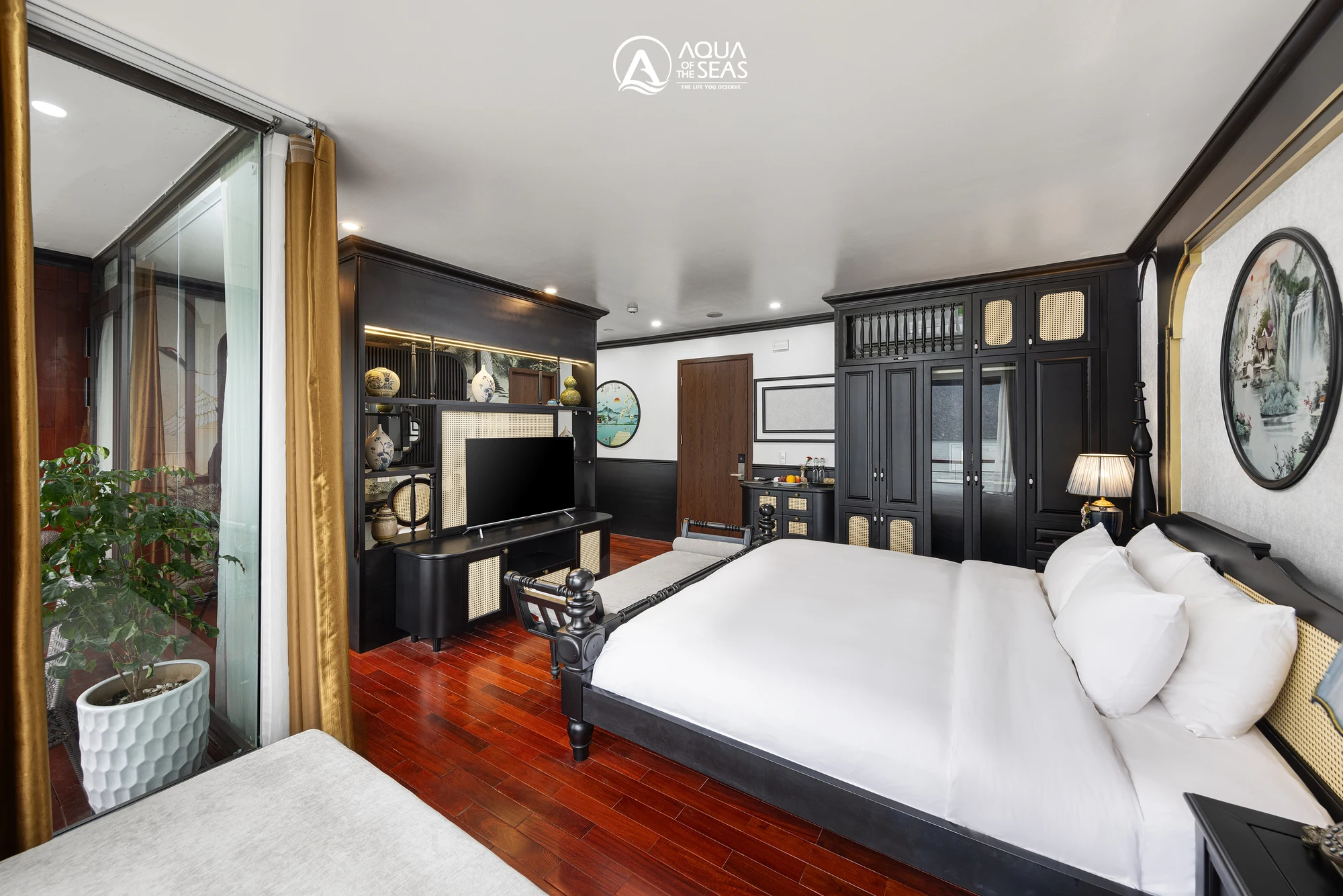 Queen Suite Balcony cabin with a black four-poster double bed on Aqua Of The Seas Cruise
